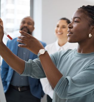 Black woman, business learning and whiteboard writing for company planning with strategy. African female employee, meeting and sales collaboration of staff working with teamwork and workshop idea.